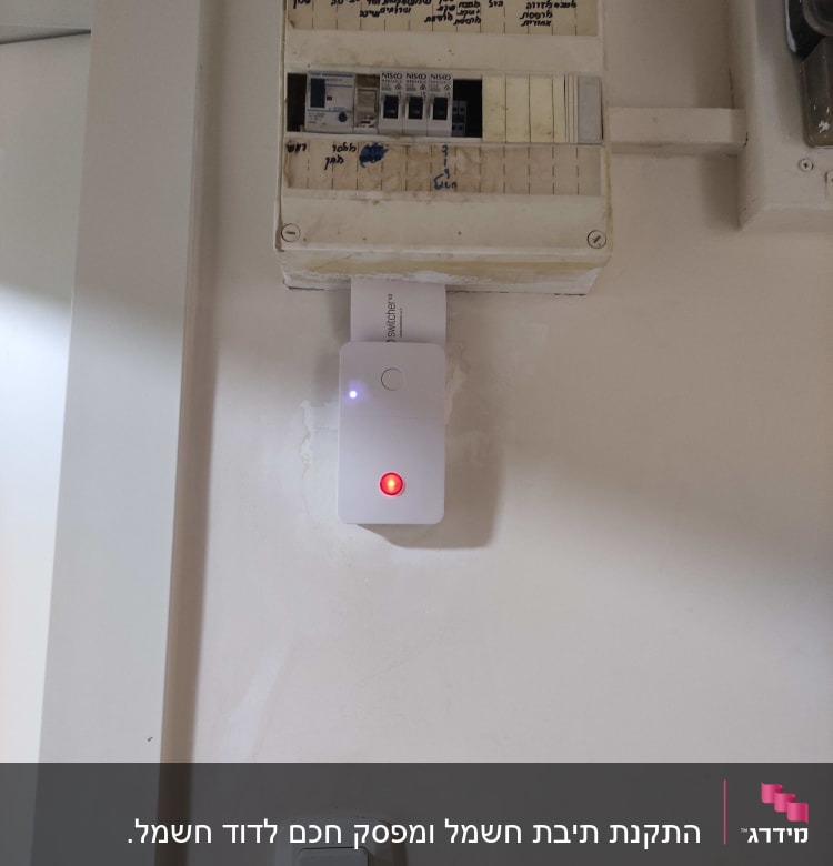 לוח חשמל עם מפסקים ומכשיר עם נורית אדומה